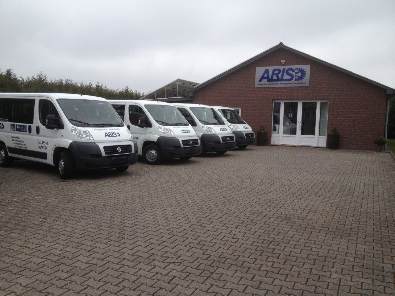 Firmengebäude der ARIS GmbH in Werlte mit Fahrzeugflotte